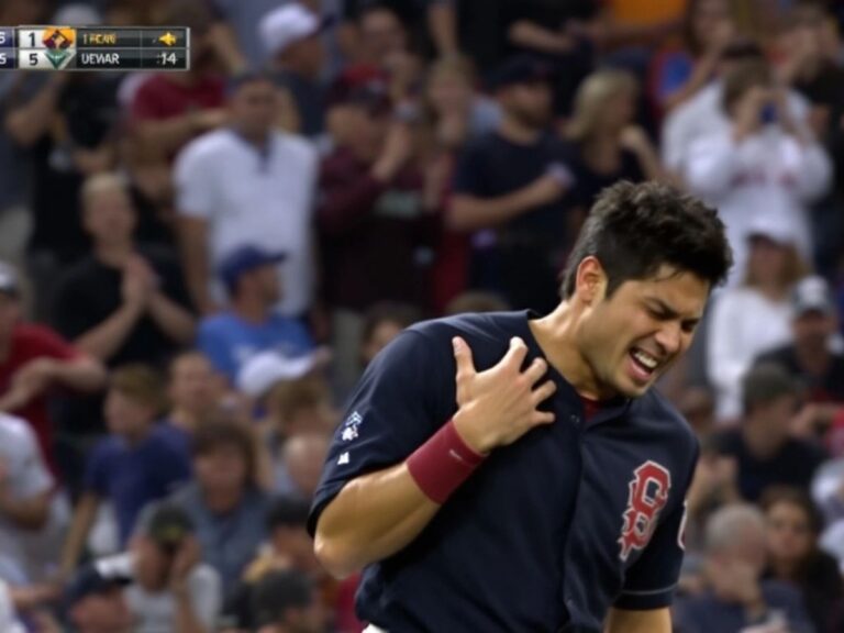 Shohei Ohtani grimacing, holding his injured shoulder.