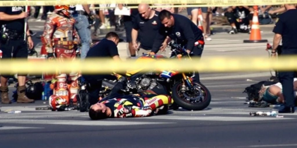 Injured motorcyclist and damaged motorcycle at crash scene.